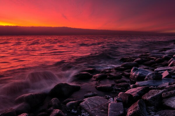 Côte rocheuse sur fond de coucher de soleil rouge