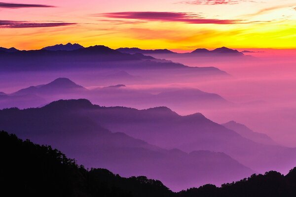 Purple mist covering the hills against the background of a bright yellow dawn