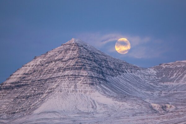 Luna piena in montagna con foschia in Islanda