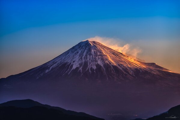 The top of the volcano is reflected at dawn