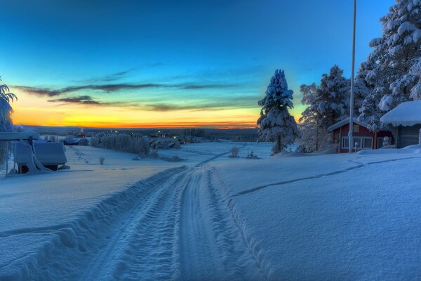 A house in the trees and a road into the sunset