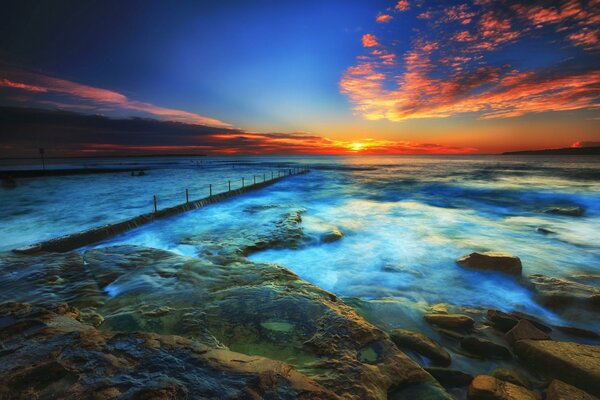 Sonnenuntergang am Meer. Steine und Wolken