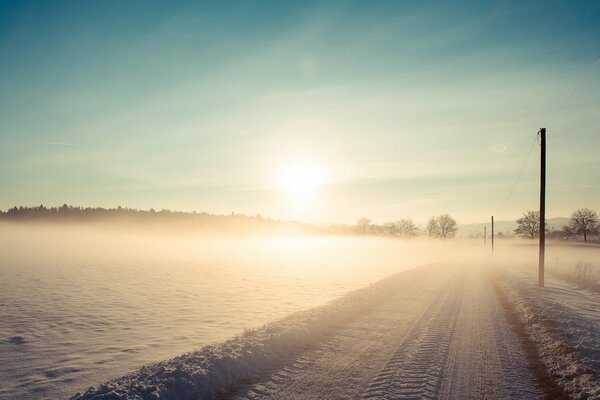 Snowy road in the rays of the winter sun