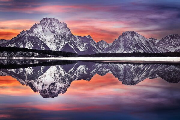 Les couleurs étonnantes du soleil sortant se reflètent dans l eau au pied des montagnes dans le parc National de grand Teton aux États-Unis