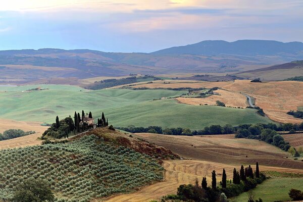 Prawdziwy krajobraz Włoch: Domy na wzgórzach, rzadkie drzewa i niebo, z którego nie można oderwać wzroku