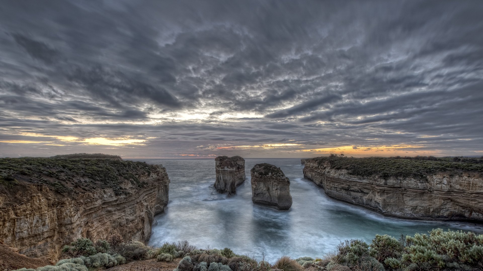 baia rocce acqua piante cielo nuvole