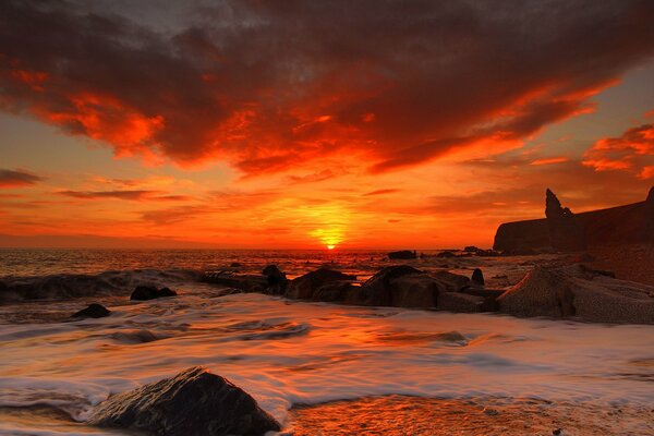 Ein purpurroter Sonnenuntergang über dem Meer. Sandstrand