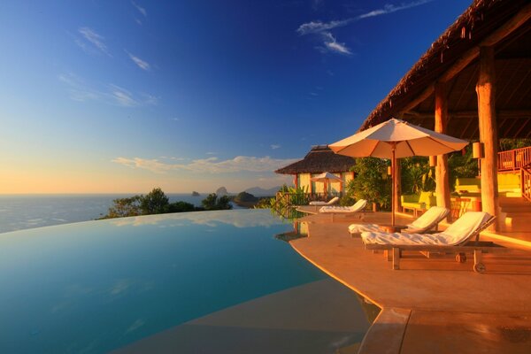 Swimming pool with sun beds and umbrella next to the pool