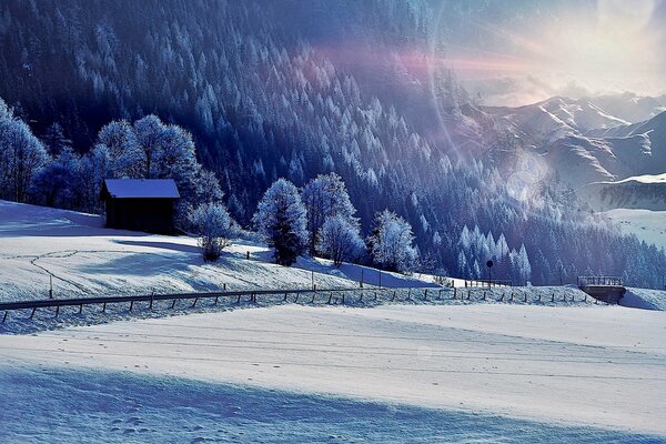 Schneereicher Winter, ein einsames Haus im Sonnenlicht