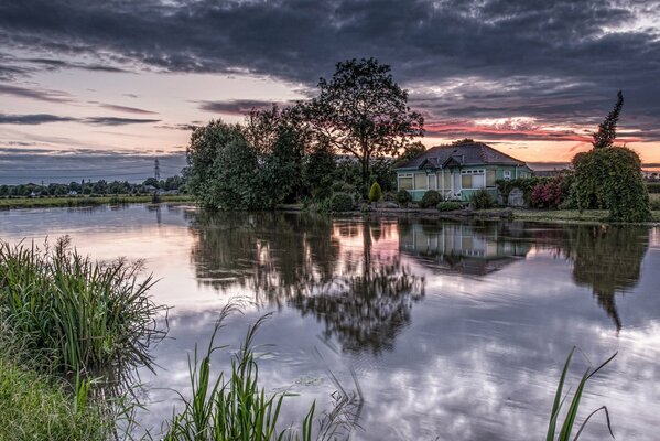 Casa junto al agua amanecer en tonos morados