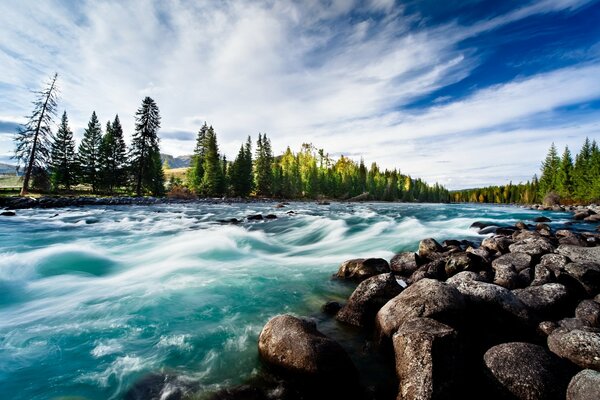 The rapid flow of the river shimmers with all shades of blue and green