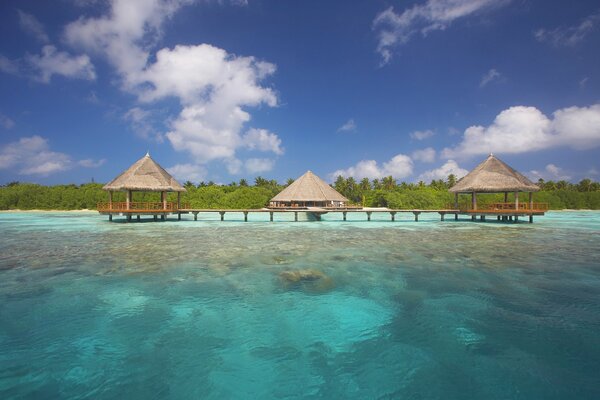 Three bungalows in the middle of the blue sea