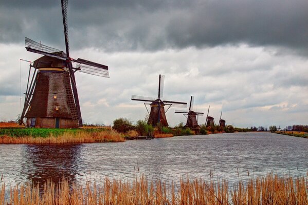 Windmühlen am Fluss unter den Wolken