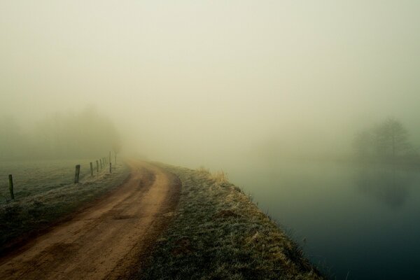 Der Weg am Fluss im Nebel vorbei