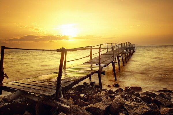 Pont dans la mer au coucher du soleil