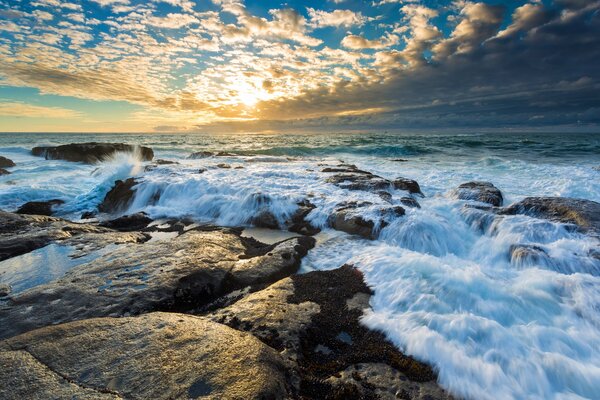 Waves and rocks at sunset