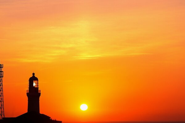 Lighthouse on the background of a bright dawn