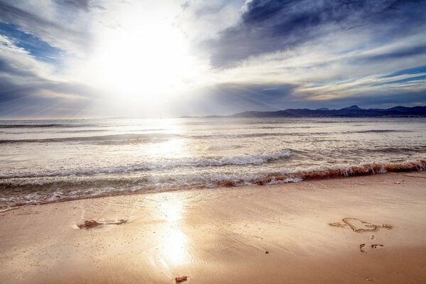 Cuore sulla sabbia della riva del mare del mattino