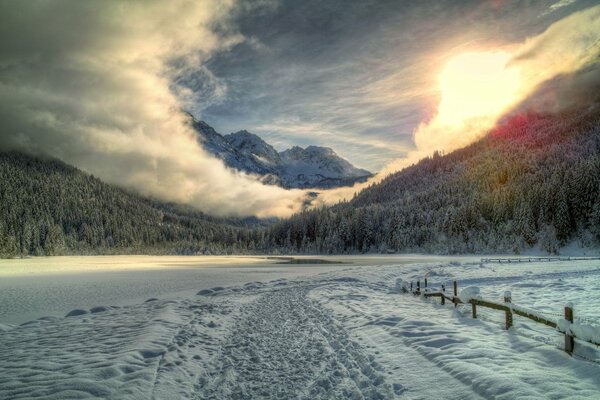 Strada innevata lungo un lago coperto di neve