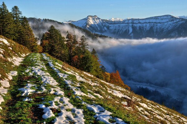 Nebel am Hang der schneebedeckten Berge