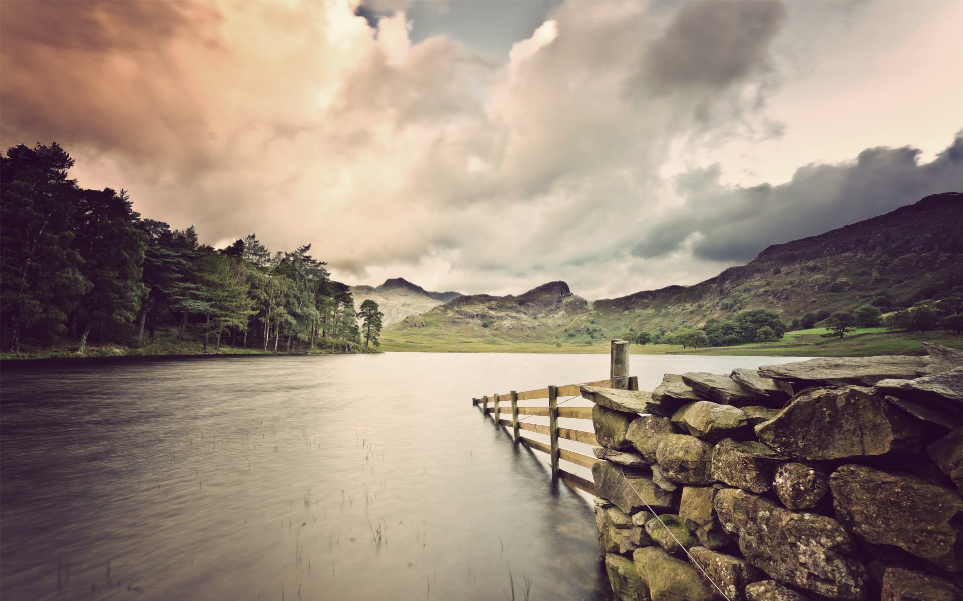 lake fence stones logs masonry trees grass clouds cloud