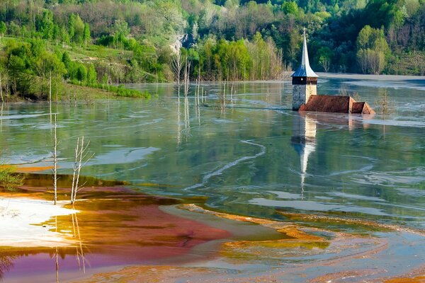 Une église noyée dans le lac, entourée d eau et de forêt