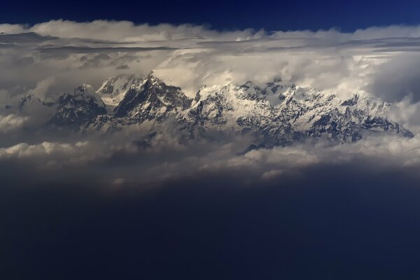 Mountains in clouds, blue sky