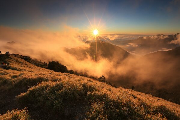 Morning fog in the mountains against the background of the rising sun