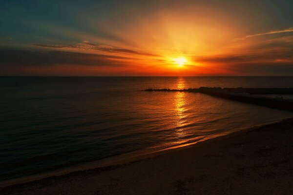 Sole al tramonto sulla spiaggia vicino al mare