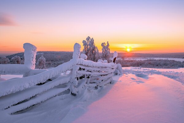 Paesaggio con recinzione sullo sfondo del tramonto invernale