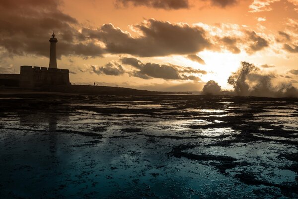 Phare sur la mer au coucher du soleil